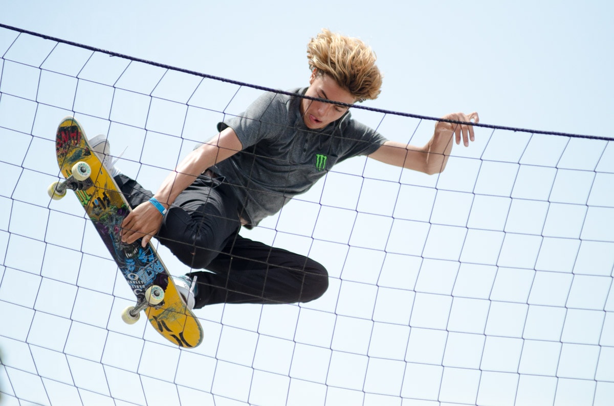 Xgames skateboarder catching air behind net — Karl Duncan Photography